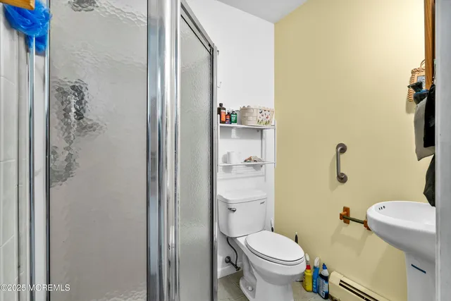 a white toilet sitting next to a bathroom sink and a shower