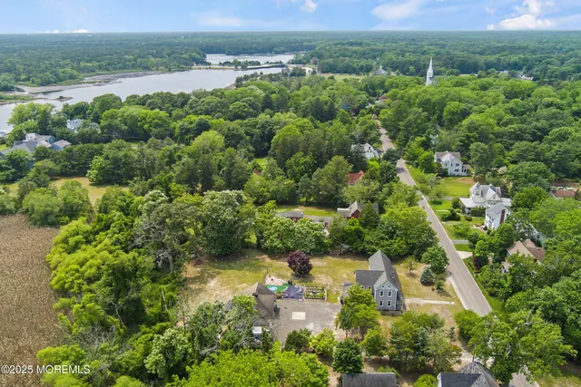 an aerial view of residential houses with outdoor space and trees