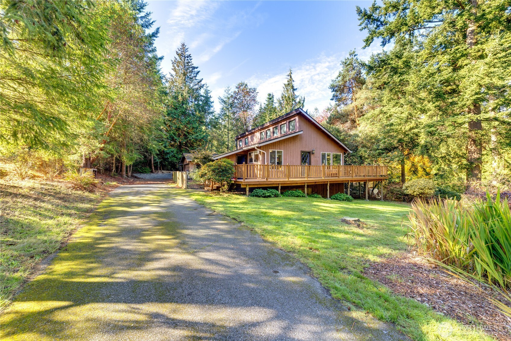 a house view with a big yard and large trees