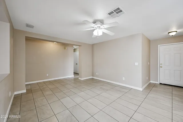 a view of an empty room and chandelier fan