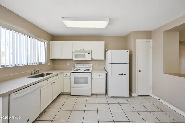 a kitchen with a sink a refrigerator and cabinets