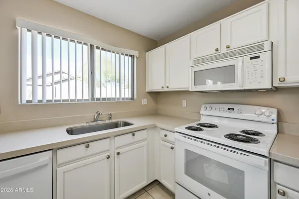 a kitchen with cabinets appliances a sink and a window
