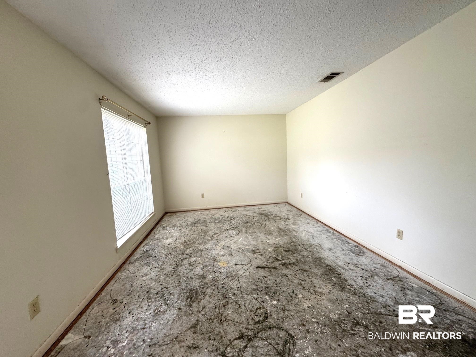 5198 Lancelot Drive Mobile, AL 36619 - Photo 2 of 30 Empty room featuring baseboards and a textured ceiling