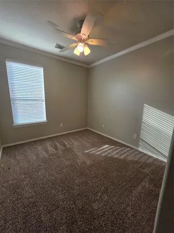 en empty room with windows and chandelier fan