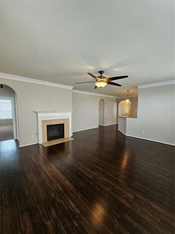 an empty room with wooden floor fireplace and windows