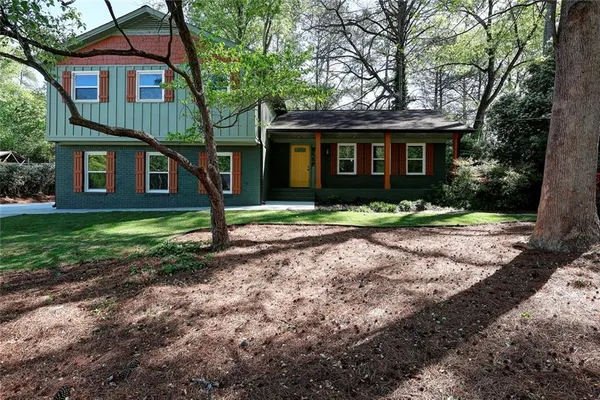 a front view of a house with a yard and trees