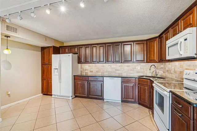 a kitchen with stainless steel appliances granite countertop a refrigerator and a stove top oven