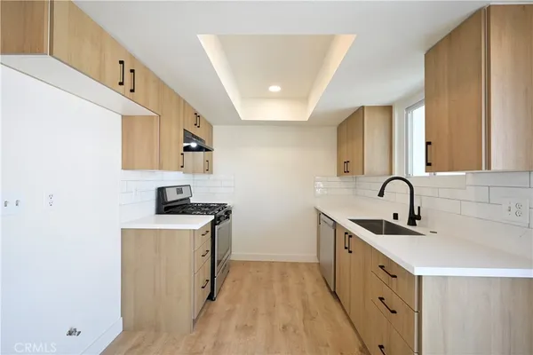 a kitchen with sink a microwave and cabinets