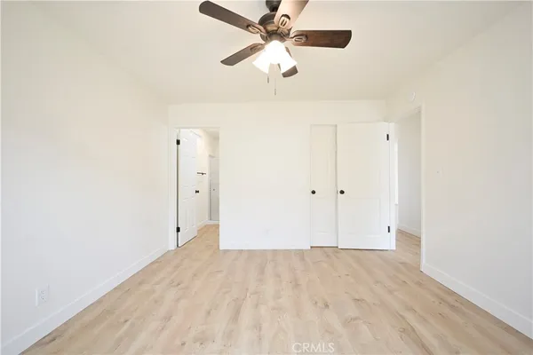 an empty room with a ceiling fan and a window