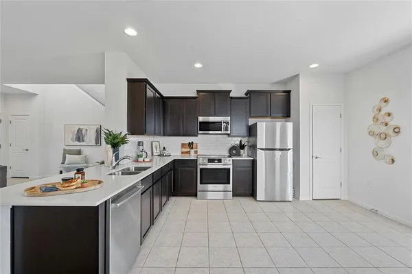 a kitchen with stainless steel appliances granite countertop a refrigerator a stove a sink dishwasher and a refrigerator with wooden floor