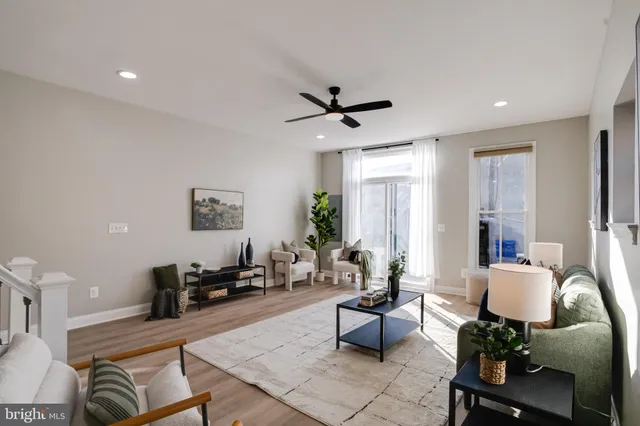 a living room with furniture hard wood floor and a window