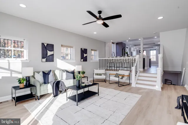 a kitchen with stainless steel appliances granite countertop a stove a refrigerator a sink a dining table and chairs with wooden floor