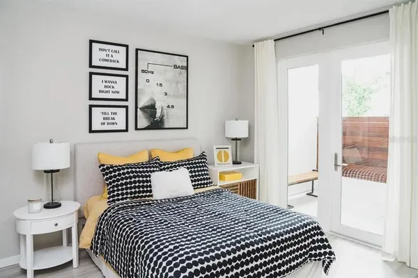 a bedroom with bed and wooden floor