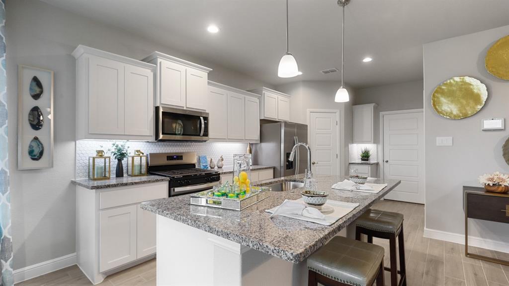 130 Castell Court Rhome, TX 76078 - Photo 37 of 39 a kitchen with a sink microwave cabinets and refrigerator