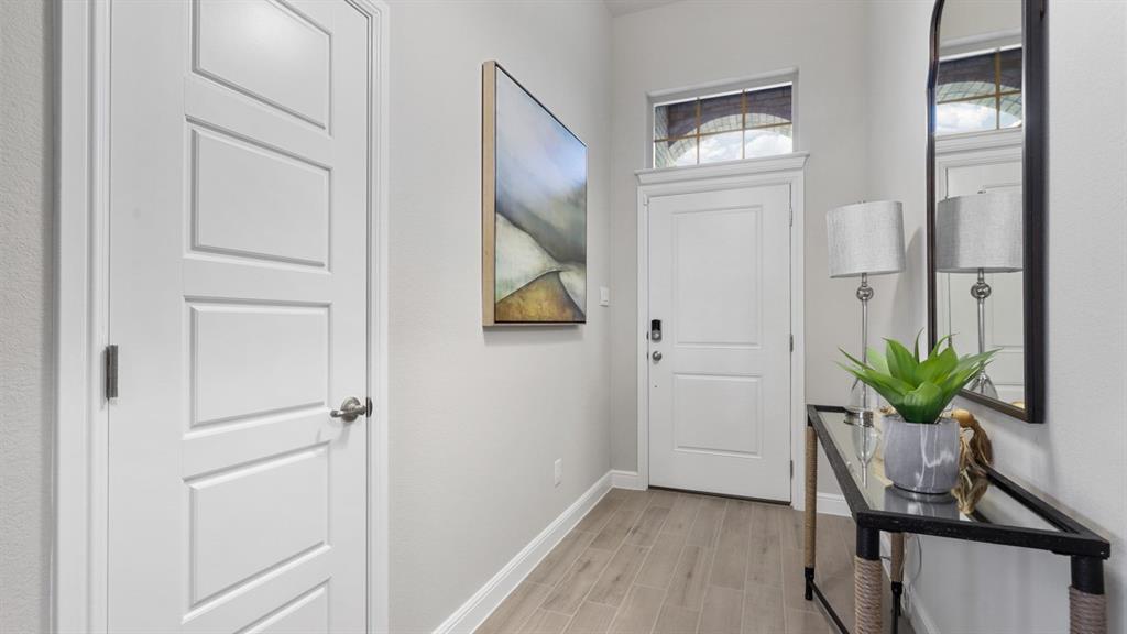 130 Castell Court Rhome, TX 76078 - Photo 23 of 39 a view of a hallway with wooden floor and a bathroom
