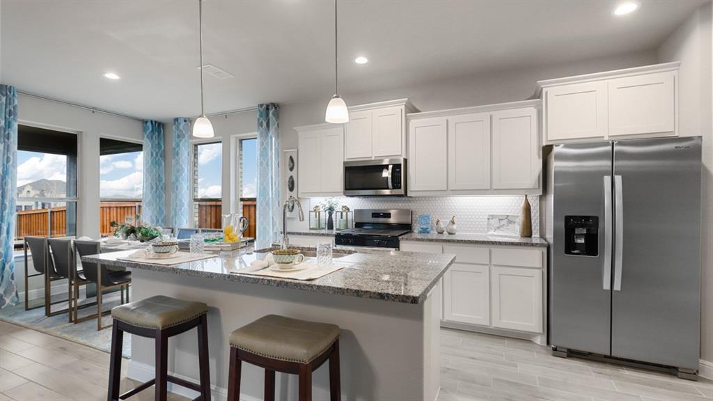 a kitchen with granite countertop a sink stove and refrigerator