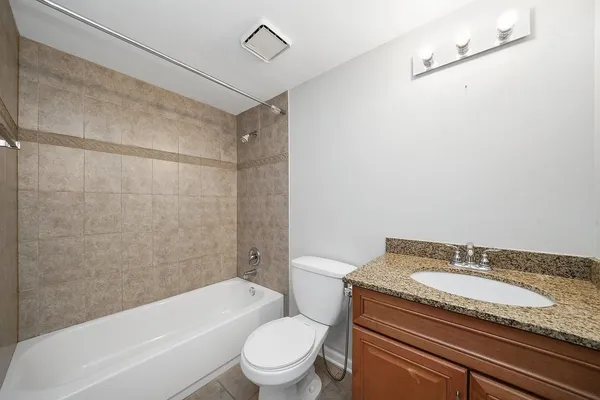 a bathroom with a granite countertop sink toilet and shower
