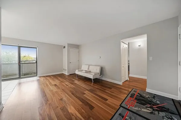 a living room with a bed and wooden floor