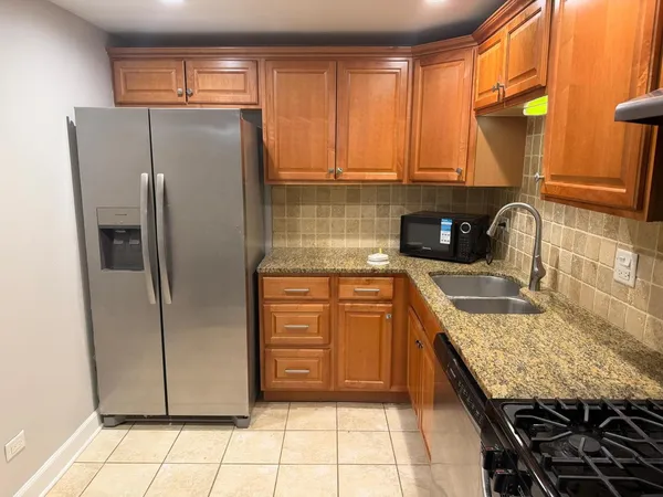 a kitchen with stainless steel appliances granite countertop a refrigerator and a stove