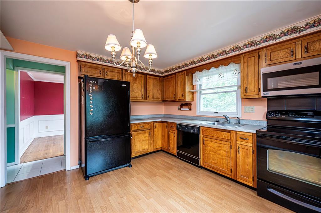 3221 Attleboro Road Greensburg, PA 15601 - Photo 9 of 38 a kitchen with stainless steel appliances granite countertop a refrigerator a stove and a wooden floors