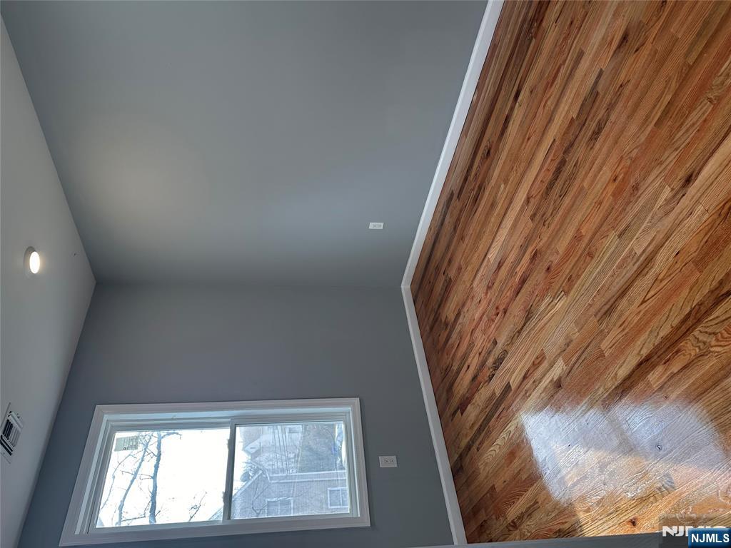 22 Knickerbocker Avenue Paterson, NJ 07503 - Photo 5 of 10 a view of empty room with wooden floor and fan
