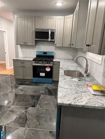 a kitchen with stainless steel appliances granite countertop a sink stove and microwave