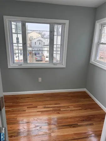 a view of a room with wooden floor and window
