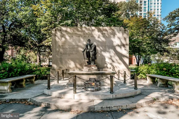 a view of fountain with tree in the background