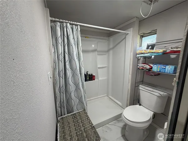 a bathroom with a toilet and a shower