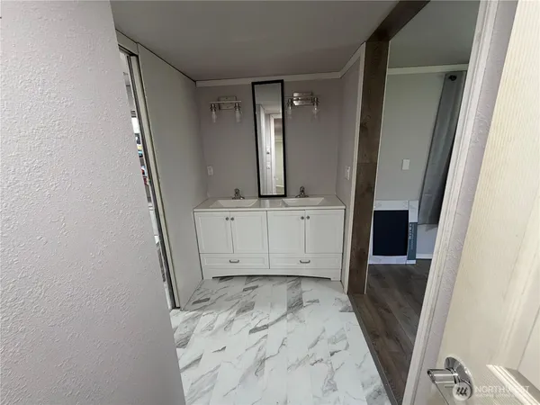 a view of a utility room with closet wooden floor and windows