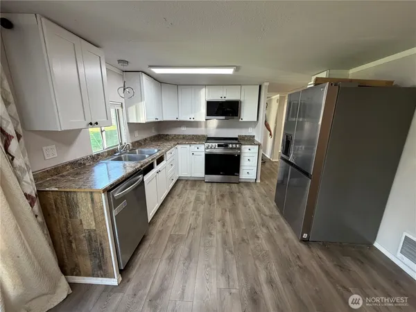a kitchen with stainless steel appliances granite countertop a refrigerator and a stove