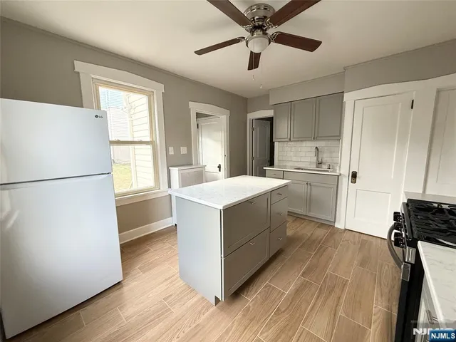 a kitchen with a refrigerator and white cabinets
