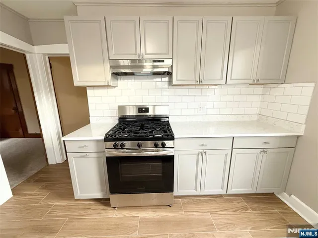 a kitchen with stainless steel appliances granite countertop a stove a refrigerator and cabinets