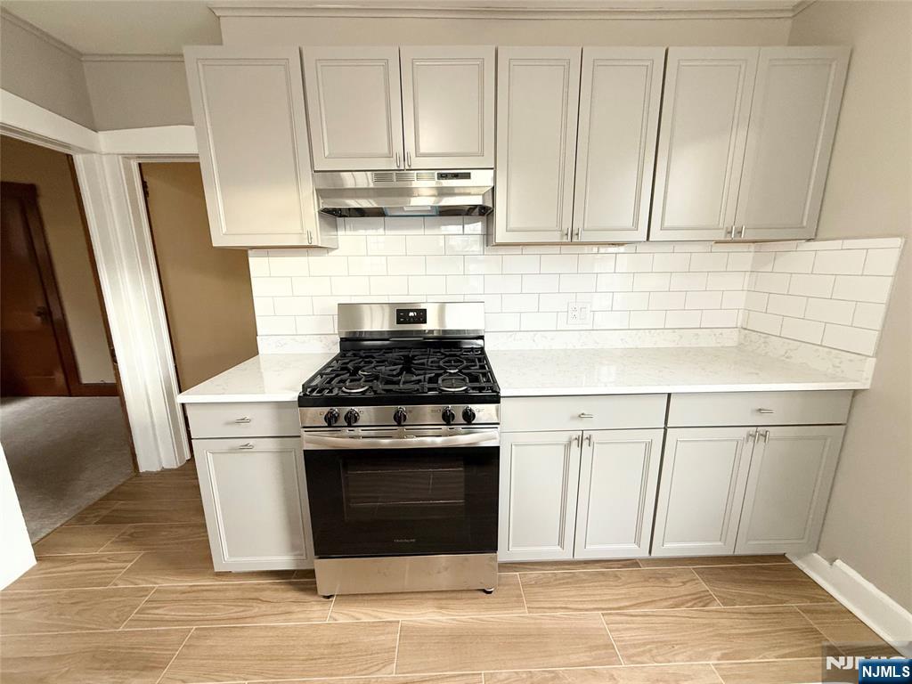140 Westervelt Avenue, Unit 1 Hawthorne, NJ 07506 - Photo 5 of 20 a kitchen with stainless steel appliances granite countertop a stove a refrigerator and cabinets