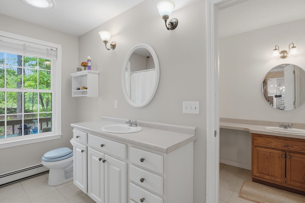 186 Common Street Groton, MA 01450 - Photo 14 of 28 a bathroom with a toilet a sink a mirror and a window
