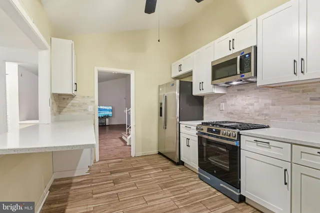 a kitchen with stainless steel appliances a stove microwave and refrigerator