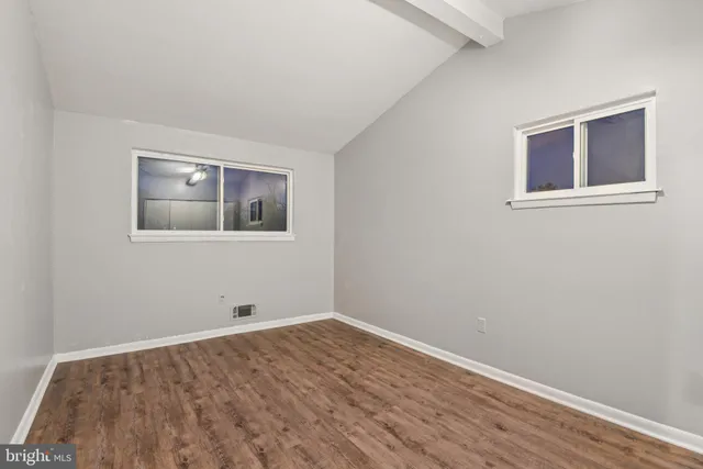 a view of a room with wooden floor and windows