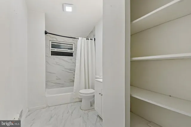 a bathroom with a toilet a sink and shower