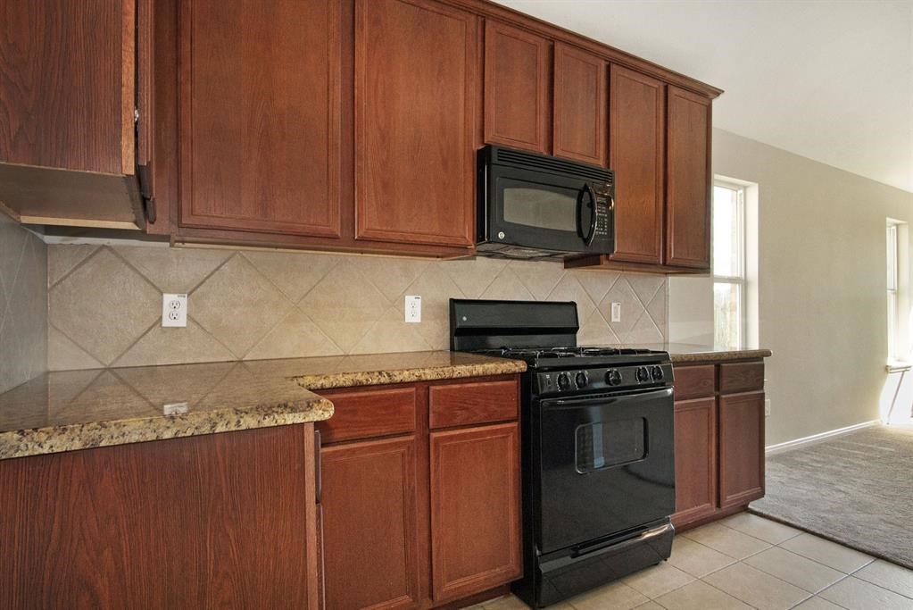 127 Rodeo Drive Manvel, TX 77578 - Photo 8 of 14 a kitchen with stainless steel appliances granite countertop a stove microwave and sink