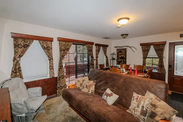 a living room with furniture and a dining table with wooden floor
