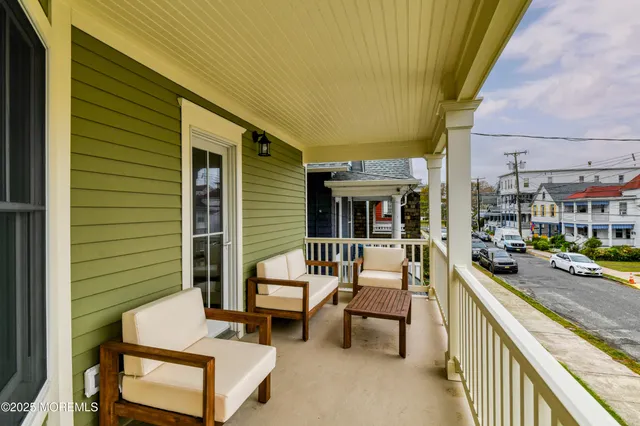 a balcony with couple of chairs and a stove