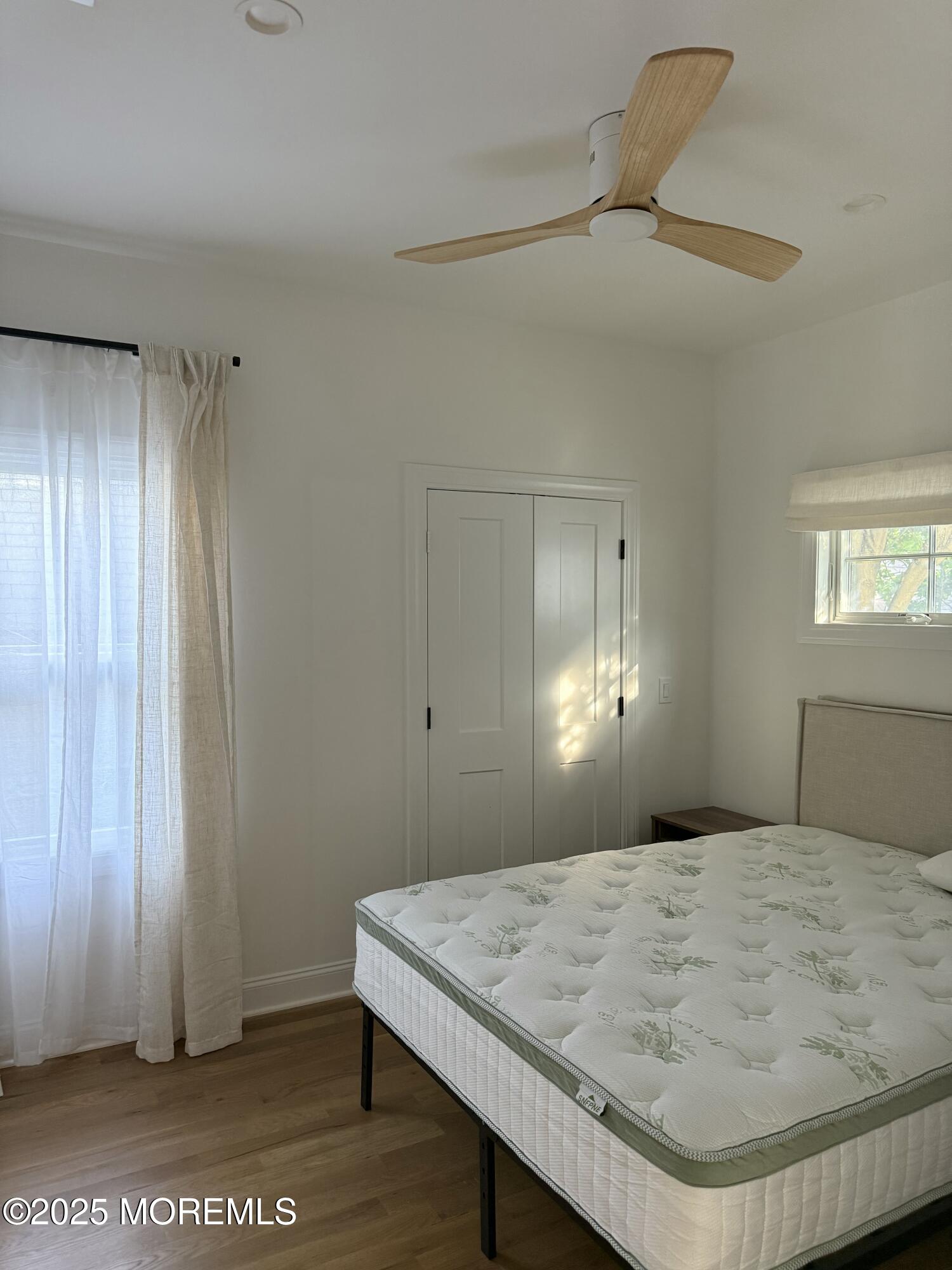 22 Atlantic Avenue Ocean Grove, NJ 07756 - Photo 7 of 8 a bedroom with a bed and a chandelier fan