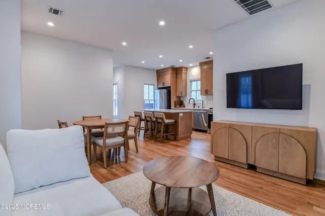 a living room with furniture a flat screen tv and kitchen view