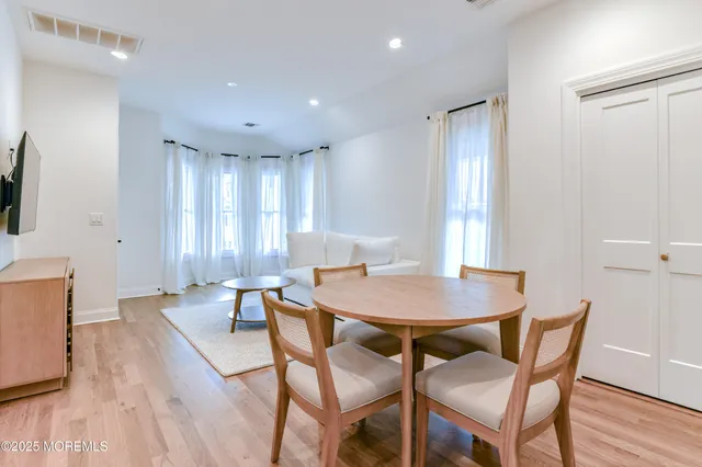 a view of a a dining room with furniture window and wooden floor
