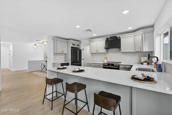 a kitchen with a sink a stove and chairs