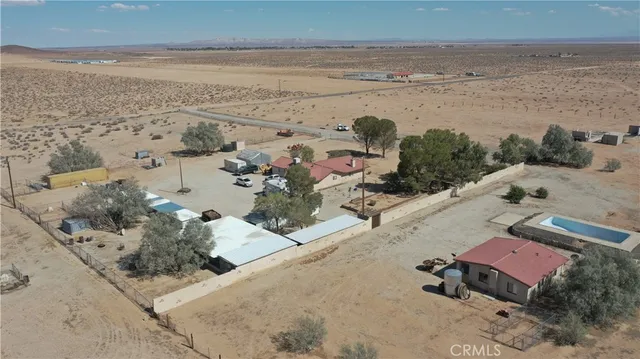 a view of a terrace with a table and chairs under an umbrella
