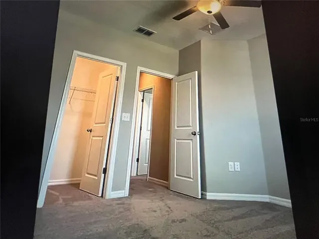 an empty room with a window and a fan