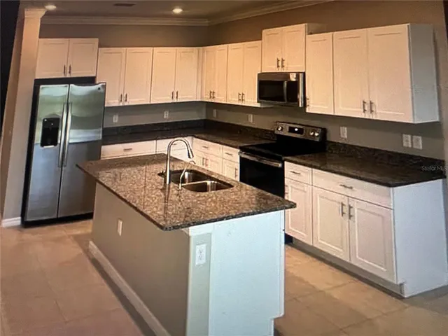 a kitchen with granite countertop a sink and stainless steel appliances