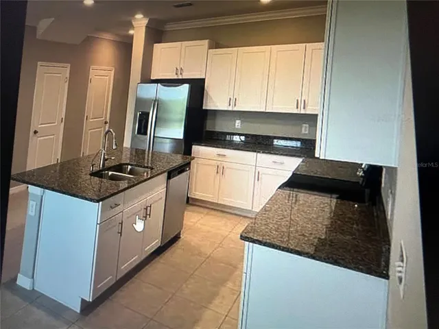 a kitchen with stainless steel appliances granite countertop a stove a sink and a refrigerator