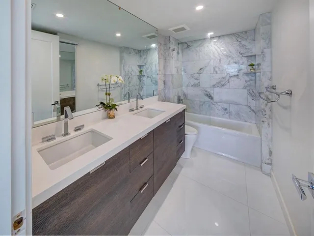 a bathroom with a double vanity sink mirror double and bathtub